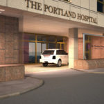 Entrance of The Portland Hospital, featuring a white car parked at the doorway, with modern architecture and signage visible.